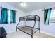 Small bedroom with a metal bunk bed and teal curtains at 6906 N Clark Ave, Tampa, FL 33614