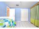 Light blue bedroom with a white bed and tile floors at 6906 N Clark Ave, Tampa, FL 33614