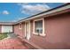 Home's exterior features a pink stucco wall, white door, and window air conditioner at 6906 N Clark Ave, Tampa, FL 33614