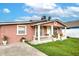 Pink stucco house with white columns and a landscaped yard at 6906 N Clark Ave, Tampa, FL 33614