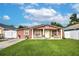 Pink stucco house with white columns and a well-maintained lawn at 6906 N Clark Ave, Tampa, FL 33614