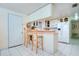 Kitchen with breakfast bar, white cabinets, and pink countertops at 6906 N Clark Ave, Tampa, FL 33614