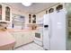 Clean kitchen features white appliances and white cabinets with pink countertops at 6906 N Clark Ave, Tampa, FL 33614