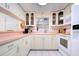 Efficient kitchen with white cabinets, pink countertops, and modern appliances at 6906 N Clark Ave, Tampa, FL 33614