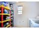 Bright laundry room with shelving for storage and cleaning supplies at 6906 N Clark Ave, Tampa, FL 33614