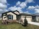 Charming single-story home featuring stone accents, a manicured lawn, and a two-car garage at 8135 Tea Olive Ter, Palmetto, FL 34221