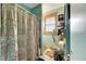 Small bathroom with shower/tub combo, tile flooring, and window for natural light at 810 E New Orleans Ave, Tampa, FL 33603