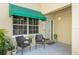 Inviting front porch with awning and two wicker chairs at 10823 Indian Hills Ct # 32, Seminole, FL 33777