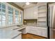 Kitchen features white cabinets, granite counters, and built-in desk at 10823 Indian Hills Ct # 32, Seminole, FL 33777