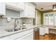 White kitchen cabinets, granite countertops, and a double sink at 10823 Indian Hills Ct # 32, Seminole, FL 33777