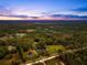 Aerial shot of property showcasing expansive land and pond at 655 Appaloosa Rd, Tarpon Springs, FL 34688