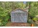 White storage shed with diamond-patterned lattice doors at 655 Appaloosa Rd, Tarpon Springs, FL 34688