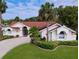 Inviting single-story home features manicured landscaping, double-door entry, and a brick-red roof at 2831 Jarvis Cir, Palm Harbor, FL 34683