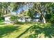 View of the backyard and the back of the home, with mature trees casting shadows at 5824 11Th St, Zephyrhills, FL 33542