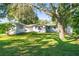 View of the backyard that is landscaped and has green grass at 5824 11Th St, Zephyrhills, FL 33542