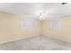 Bedroom showcasing neutral walls, ceiling fan, and natural light from two windows at 5824 11Th St, Zephyrhills, FL 33542