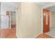 Hallway view leading to a bedroom, showing the connecting flooring and neutral wall colors at 5824 11Th St, Zephyrhills, FL 33542