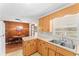 Functional kitchen with a double stainless steel sink, wood cabinets and a view to the dining area at 5824 11Th St, Zephyrhills, FL 33542