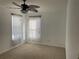 Clean carpeted bedroom featuring two windows dressed with sheer, white curtains, and a ceiling fan at 423 Chimney Rock Dr, Ruskin, FL 33570