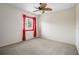 Bright carpeted bedroom with a ceiling fan, and window with bright red drapes to allow natural light at 423 Chimney Rock Dr, Ruskin, FL 33570