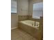 Tiled bathtub with two windows providing natural light at 13034 Avalon Crest Ct, Riverview, FL 33579