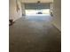 Spacious garage with an open door showing the driveway and a car in the distance at 13034 Avalon Crest Ct, Riverview, FL 33579