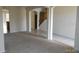 Open-concept living area with carpeted floors, archways, and access to a wooden staircase at 13034 Avalon Crest Ct, Riverview, FL 33579