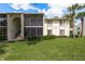 Exterior view of condo building with well-manicured lawn at 3133 Lake Pine Way # D1, Tarpon Springs, FL 34688