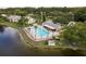 Community pool with lake view and lounge chairs at 3133 Lake Pine Way # D1, Tarpon Springs, FL 34688