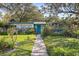Ranch style home with teal accents, walkway, and mature landscaping at 509 Langford Cir, Plant City, FL 33563
