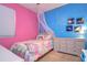 Vibrant bedroom with colorful bedding, a modern dresser, and bright pink and blue walls at 8125 Stone Path Way, Tampa, FL 33647