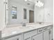 Double vanity bathroom with white cabinets and quartz countertop at 13728 Sunlight Meadow Dr, Riverview, FL 33578