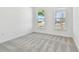 Bright bedroom with grey carpet and two large windows at 13728 Sunlight Meadow Dr, Riverview, FL 33578