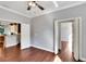 Bedroom with hardwood floors featuring an open doorway to the bathroom and kitchen at 11335 Flora Springs Dr, Riverview, FL 33579