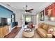 Inviting living room with a ceiling fan, hardwood floors, and lots of natural light at 11335 Flora Springs Dr, Riverview, FL 33579