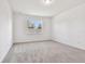 Simple bedroom with grey carpet and a large window at 13806 Sunlight Meadow Dr, Riverview, FL 33578