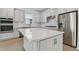 Modern kitchen featuring white cabinetry, stainless steel appliances, and a large island at 13808 Sunlight Meadow Dr, Riverview, FL 33578