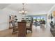 Open concept dining area with a view of the living room and balcony, featuring a round glass table and wicker chairs at 1120 N Shore Ne Dr # 703, St Petersburg, FL 33701