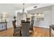 Dining area with a view into the kitchen, showcasing light wood floors and a round glass table with wicker chairs at 1120 N Shore Ne Dr # 703, St Petersburg, FL 33701