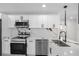 Modern white kitchen with stainless steel appliances and marble countertops at 2906 W Braddock St, Tampa, FL 33607