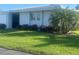 Well-maintained lawn with a mature palm tree and foundation shrubbery in front of house at 3280 Southfield Ln # 804, Sarasota, FL 34239