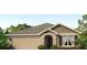 Tan one-story house with a two-car garage and arched entryway at 6223 Distant Haze Pl, Palmetto, FL 34221