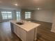 Open concept kitchen with island, white cabinets, and view into living area at 6223 Distant Haze Pl, Palmetto, FL 34221