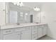 Double vanity bathroom with a large mirror and bright lighting at 13810 Sunlight Meadow Dr, Riverview, FL 33578