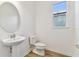 Clean powder room features a pedestal sink and toilet at 13810 Sunlight Meadow Dr, Riverview, FL 33578