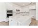 Modern kitchen with white cabinets, quartz countertops, and stainless steel appliances at 13810 Sunlight Meadow Dr, Riverview, FL 33578