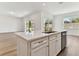 Large kitchen island with white cabinets and quartz countertop at 13810 Sunlight Meadow Dr, Riverview, FL 33578