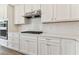 White kitchen cabinets, quartz countertops and gas cooktop at 13810 Sunlight Meadow Dr, Riverview, FL 33578