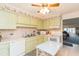 Kitchen with light wood cabinets, white appliances, and a breakfast bar at 4027 Davit Dr, New Port Richey, FL 34652