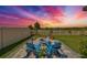 Landscaped backyard with fire pit and seating area at sunset at 5429 Rainwood Meadows Dr, Apollo Beach, FL 33572